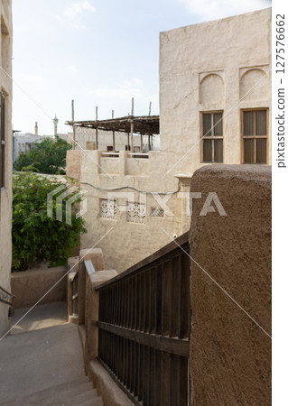 Old town in Al Seef Cultural Historical District on shores of Dubai Creek. Tourist place with old streets, houses and shops, Dubai, UAE. Vertical photo Old town in Al Seef Cultural Historical District on shores of Dubai Creek. Tourist place with old streets, houses and shops, Dubai, UAE. Vertical photo 127576662