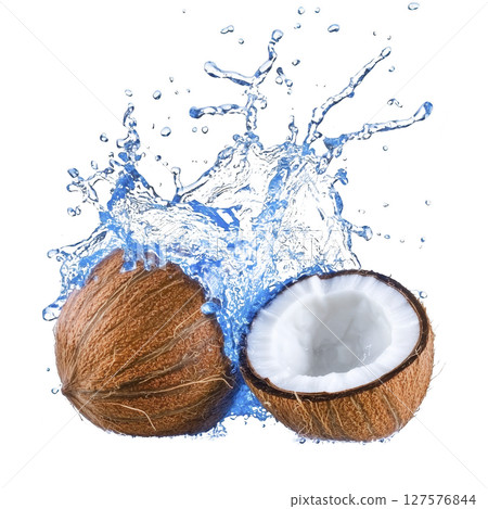 Whole coconut and halved coconut with water splashing around them create refreshing and tropical vibe. brown shell contrasts with white flesh and blue water splash 127576844