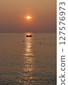 the atmosphere of the fishermen in the evening after returning home from fishing in the sea using a wooden boat 127576973