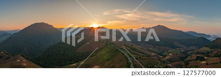 Aerial view of The sun shines in rays over the mountain peaks 127577000