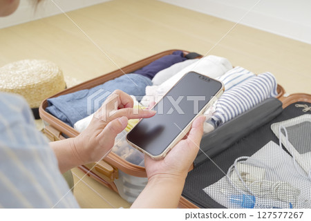 A woman checking a checklist on her smartphone A woman checking a checklist on her smartphone 127577267