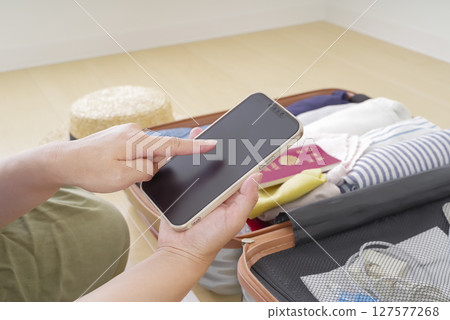 一位女士正在用智慧型手機查看清單 127577268