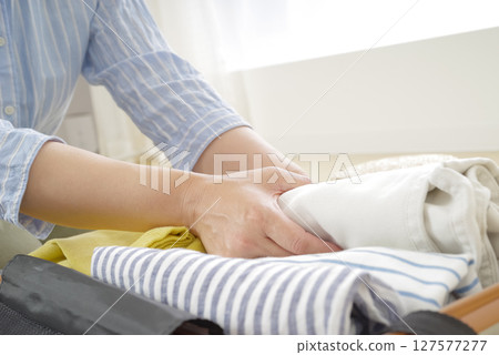 A woman packing her travel gear 127577277