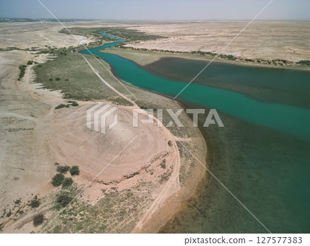 Aerial view of a winding river channel and sandy hills near Kuimazar Reservoir Aerial view of a winding river channel and sandy hills near Kuimazar Reservoir 127577383