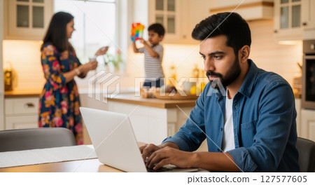 Coworkers discussing over a laptop in a casual workspace. 127577605