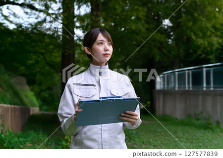 A woman in work clothes performing maintenance 127577839