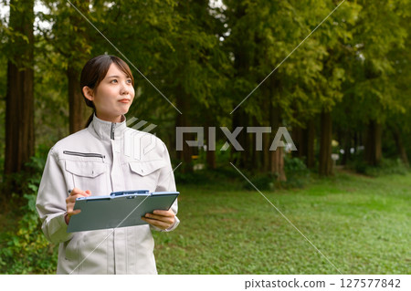 A woman in work clothes performing maintenance 127577842