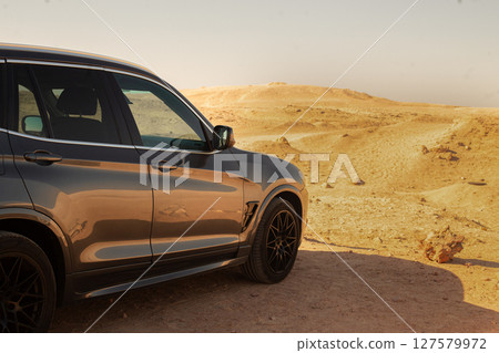 SUV Driving Through Egyptian Desert Landscape  127579972
