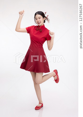 Full body portrait of joyful beauty Asian woman in red Cheongsam Chinese traditional dress celebrating and dancing isolated on white background. 127580267
