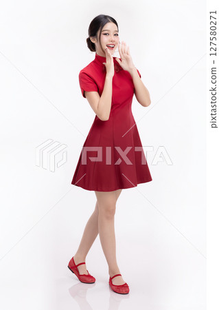 Full body portrait of joyful beauty Asian woman in red Cheongsam Chinese traditional dress celebrating and announcing isolated on white background. 127580271
