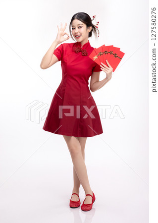 Portrait of joyful beauty Asian woman in red Cheongsam Chinese traditional dress celebrating with lucky red envelopes on Chinese New Year festival isolated on white background. 127580276