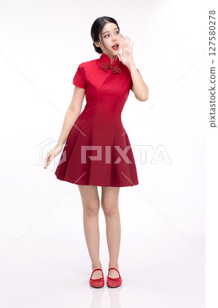 Full body portrait of joyful beauty Asian woman in red Cheongsam Chinese traditional dress celebrating and announcing isolated on white background. 127580278