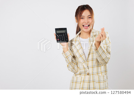 Asian accountant holding a calculator and making mini heart, then double-checks her tax results with another calculator, happy with budget calculations. isolated studio white background Asian accountant holding a calculator and making mini heart, then double-checks her tax results with another calculator, happy with budget calculations. isolated studio white background 127580494