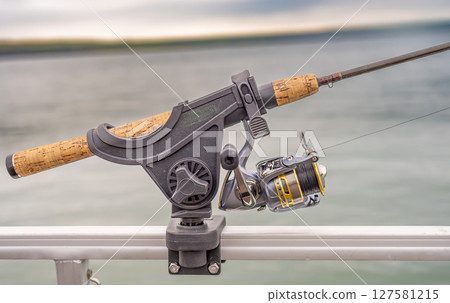 Fishing rod holder mounted on the side of a boat  127581215