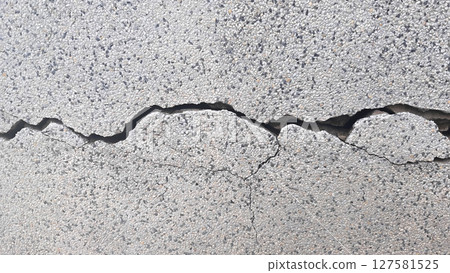 white concrete wall has cracks due to poor quality construction. 127581525