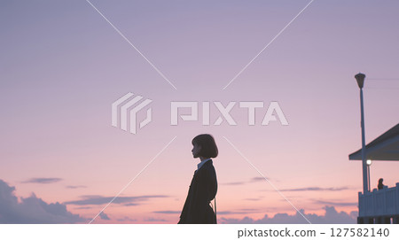 Pale pastel-colored sunset and a young woman - an emotional scene 127582140