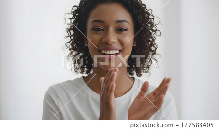 Cheerful African American Woman Laughing and Clapping in White Shirt 127583405