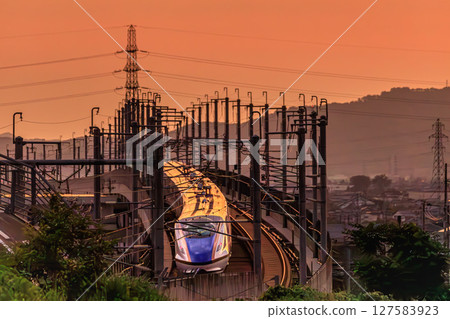 A bullet train racing through the sunset A bullet train racing through the sunset 127583923