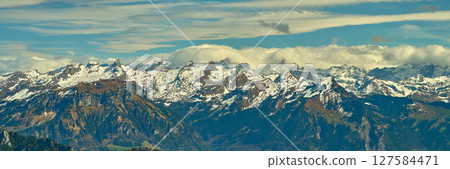 Snow-capped mountains under a clear blue sky offer breathtaking views in the Swiss Alps during early spring 127584471
