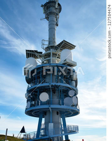 Telecommunication tower reaches sky in a mountainous location during a clear day with blue sky Telecommunication tower reaches sky in a mountainous location during a clear day with blue sky 127584474