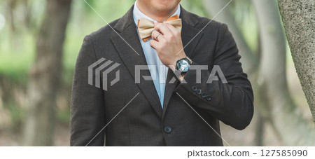 Groom in suit with bow tie Groom in suit with bow tie 127585090