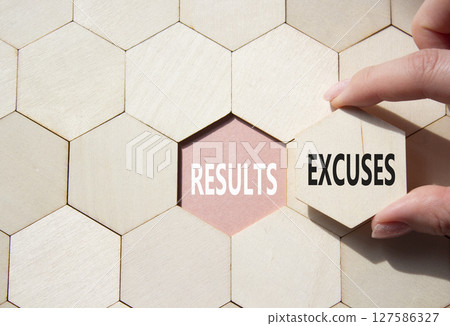 Results or Excuses symbol. Concept word Results or Excuses on wooden comb puzzle. Businessman hand. Beautiful pink background. Business and Results or Excuses concept. Copy space 127586327