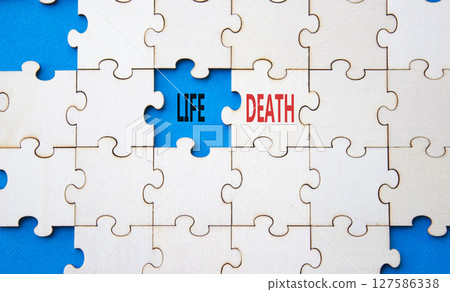 Life or Death symbol. Concept word Life or Death on wooden puzzle. Beautiful blue background. Business and Life or Death concept. Copy space Life or Death symbol. Concept word Life or Death on wooden puzzle. Beautiful blue background. Business and Life or Death concept. Copy space 127586338