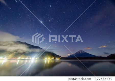 Night view of Mt. Fuji and the rising winter constellations from Lake Shojiko Night view of Mt. Fuji and the rising winter constellations from Lake Shojiko 127586430