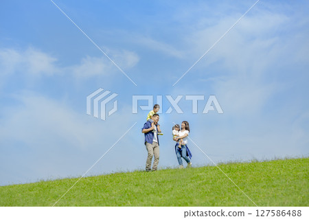 一家四口在公園的小山上玩耍 127586488