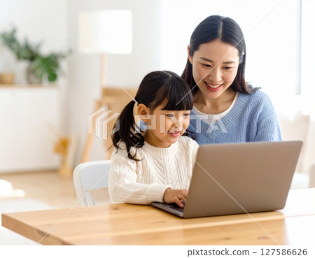 Parent and child learning to use a computer in the living room 127586626