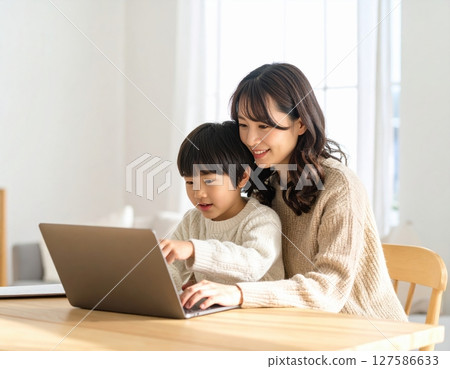 Parent and child learning to use a computer in the living room 127586633
