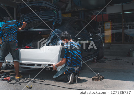 Checking car body work fiber bumper at car garage Checking car body work fiber bumper at car garage 127586727