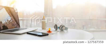 Cozy modern space with toys, laptop, headphones, and parenting objects. Copy space 127587359