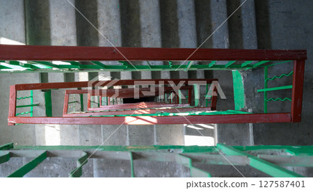 staircase in a high-rise building with green railings, top view staircase in a high-rise building with green railings, top view 127587401