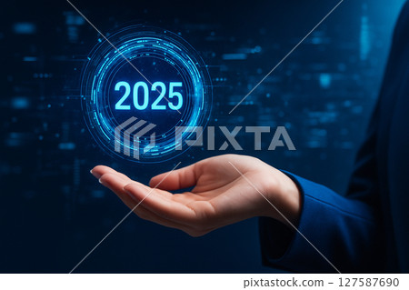 AI generated image of a woman hand gently holding a glowing holographic interface with the number 2025 in a futuristic blue digital environment suggesting strategy and innovation 127587690