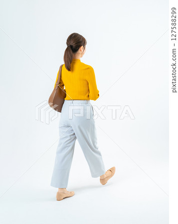 一個穿著休閒裝的女人走路的全身照片 127588299