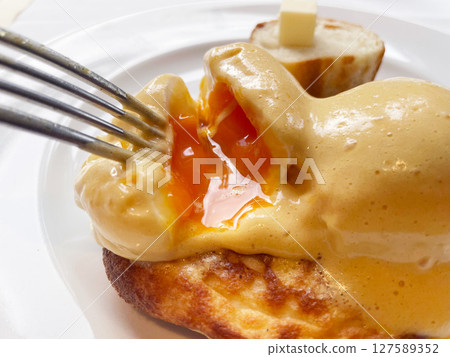 Eggs Benedict with potato pancakes and thick-sliced ham 127589352