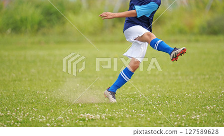 Youth soccer match (player taking free kick) 127589628