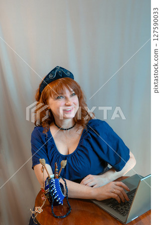 modern woman with elements of ethno-style in a costume uses the technique 127590033