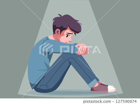 A young man sits hugging his knees in a sad or anxious mood. A young man sits hugging his knees in a sad or anxious mood. 127590874