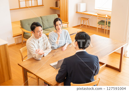一位商人和一對年輕夫婦在客廳討論生意 127591004