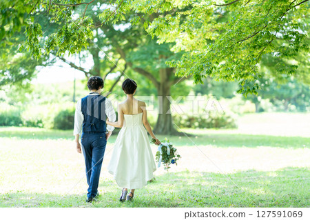 Back view of a bride and groom walking arm in arm 127591069