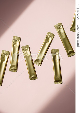 Golden Stick Packaging on Pink Background. Energy Drink and Supplement Sachet Design. Foil Pouch Mockup for Food Product. 127591129