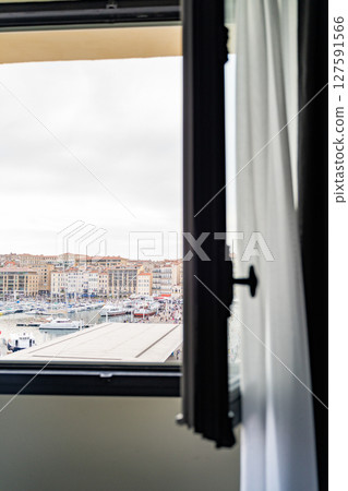 Open window to see city marina with boats along waterfront, view from apartment Open window to see city marina with boats along waterfront, view from apartment 127591566