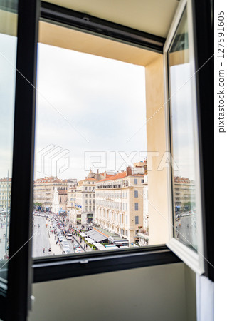 View of Marseilles through an open window of a hotel room 127591605