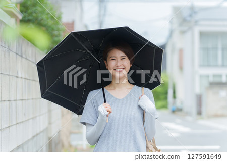 A smiling woman holding a parasol 127591649