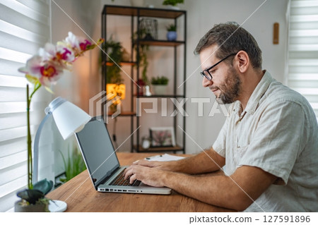 Focused professional working in a cozy home office 127591896