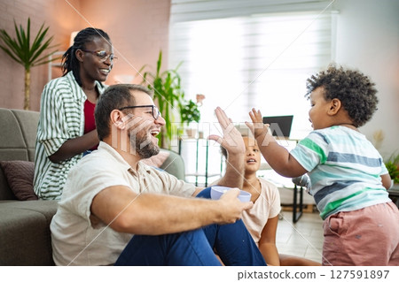 Family joy during playtime in a cozy living room 127591897