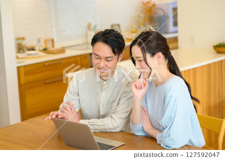 Japanese couple looking at a personal computer in the living room 127592047
