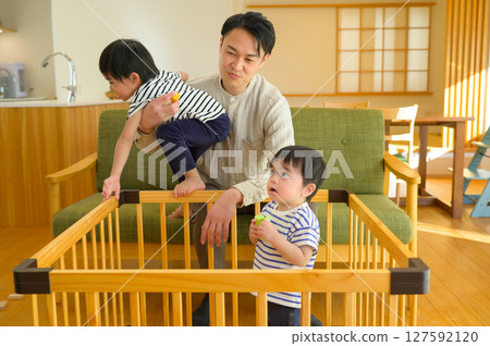 年輕的兄弟和他們的父親在籠子裡玩耍 127592120